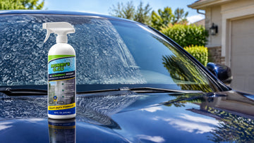 Mommy’s Glass 2-in-1 hard water spot remover on a car hood beside water-spotted vehicle glass