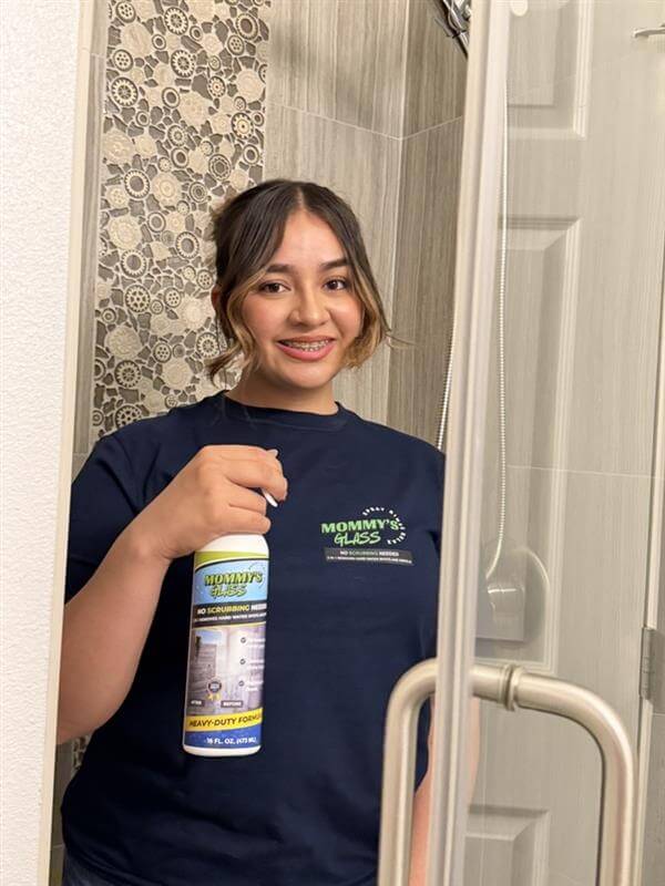 Mommy's Glass bottle positioned in a shower for treating mineral buildup